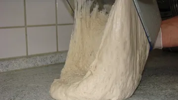 Dough being poured onto a kitchen counter.