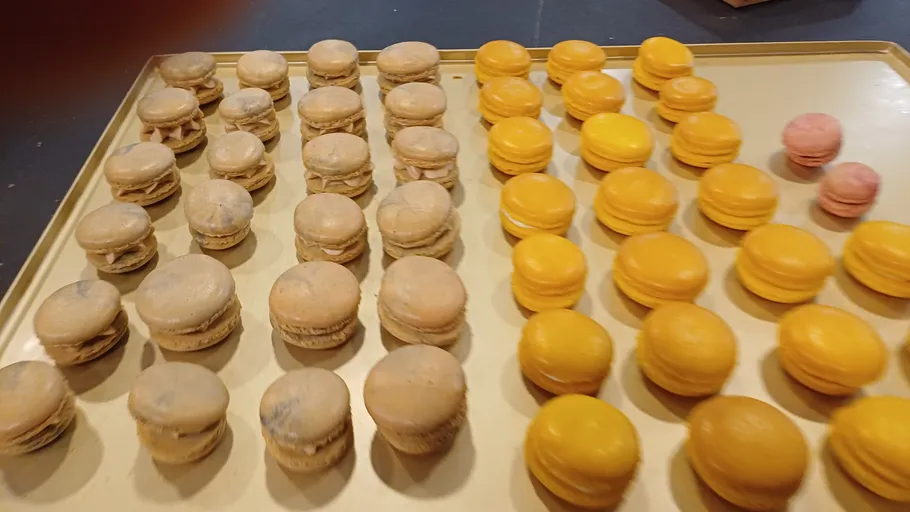 Assorted macarons arranged on a golden tray.
