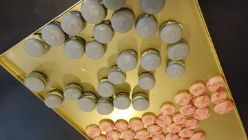 Blaue und pinke Macarons auf goldenem Tablett.