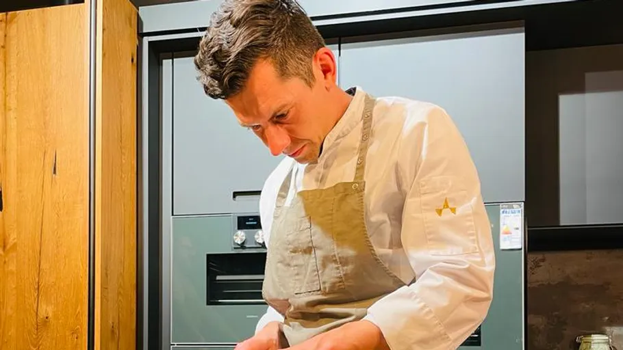 Chef prepares food in modern kitchen.