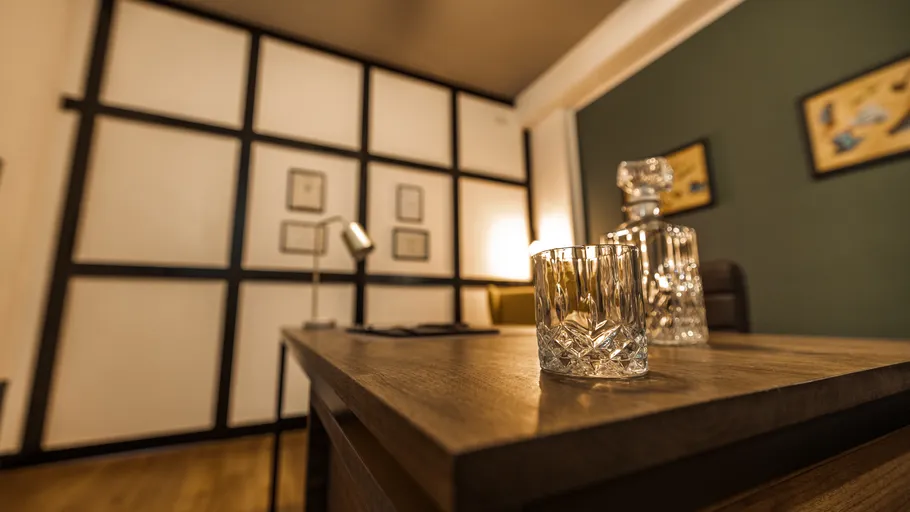 Glas auf Schreibtisch in stilvollem Büro.