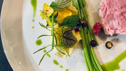 Gourmetgericht mit Fleisch, Spargel und Garnitur.