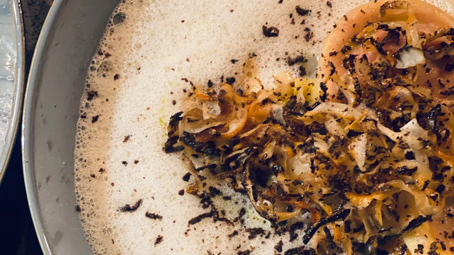 Nahaufnahme von Trüffel auf cremiger Suppe.
