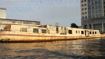 Verlassenes Boot schwimmt in der Nähe von Gebäuden.