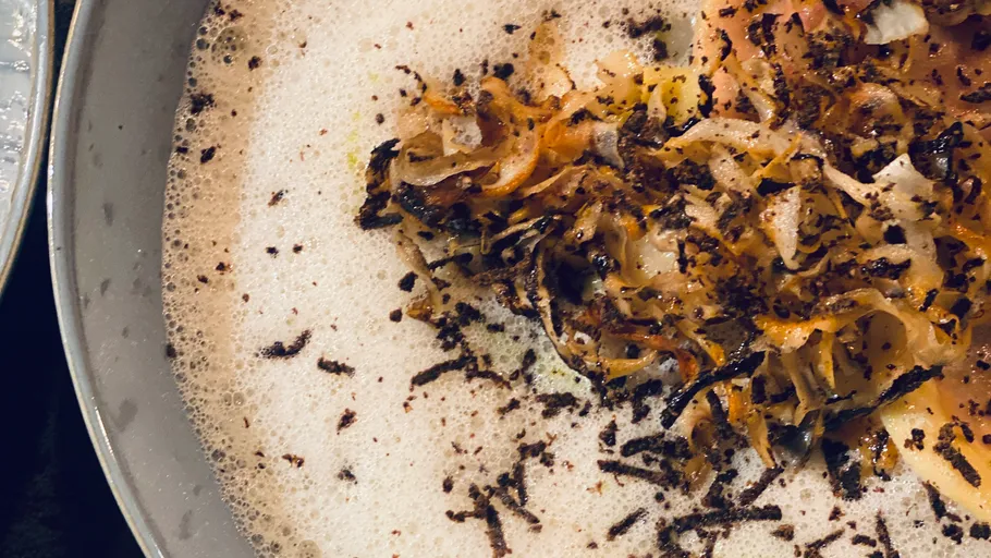 Foamy soup topped with grated truffle shavings.