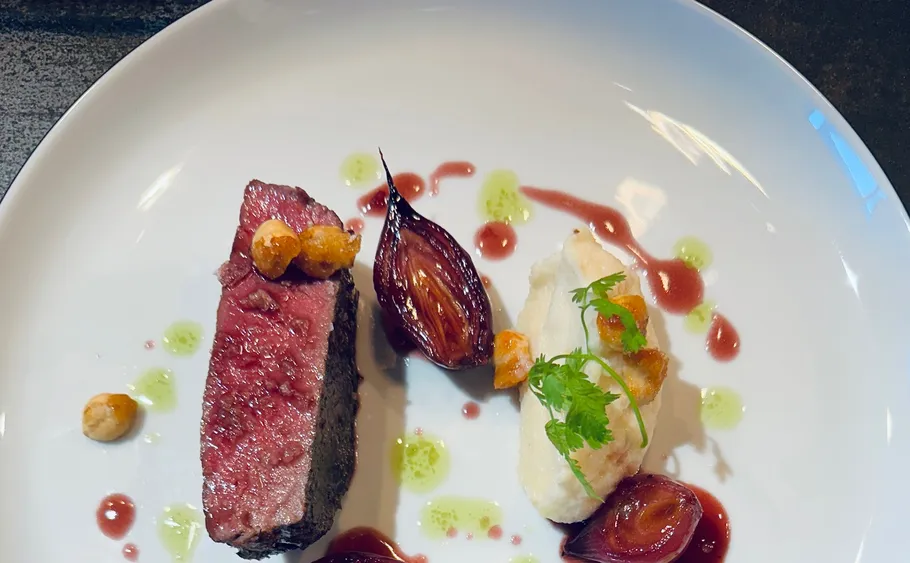 Plated gourmet dish with beef and mashed potatoes.