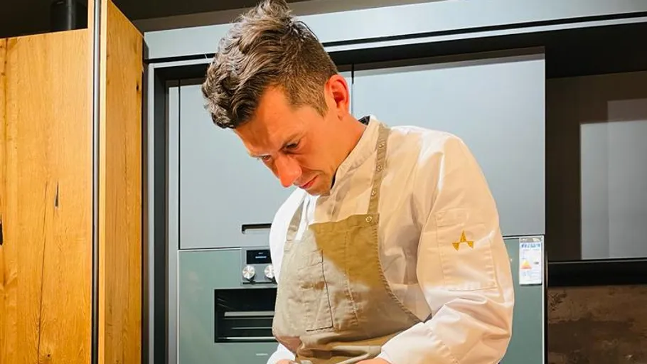 Chef prepares food in modern kitchen.