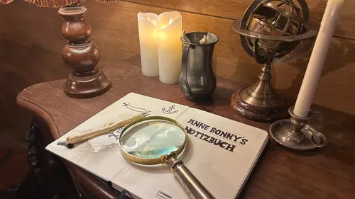 Magnifying glass on book, candles, and globe.