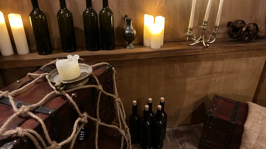 Candles, bottles, and treasure chest with rope.