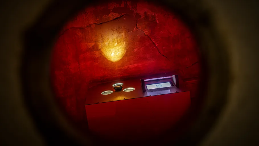 Red room with glowing light and screen.