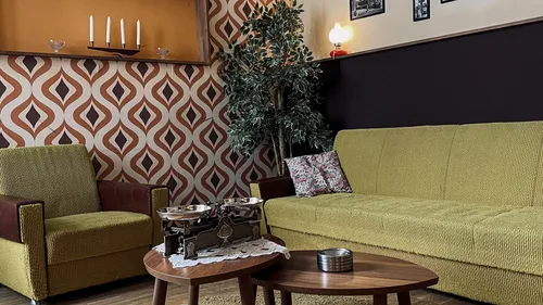 Retro-Wohnzimmer mit gemusterter Tapete, Vintage-Möbel.