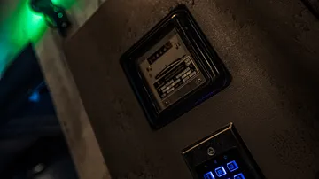 Tastatur und Panel an dunkler Wand, schwache Beleuchtung.
