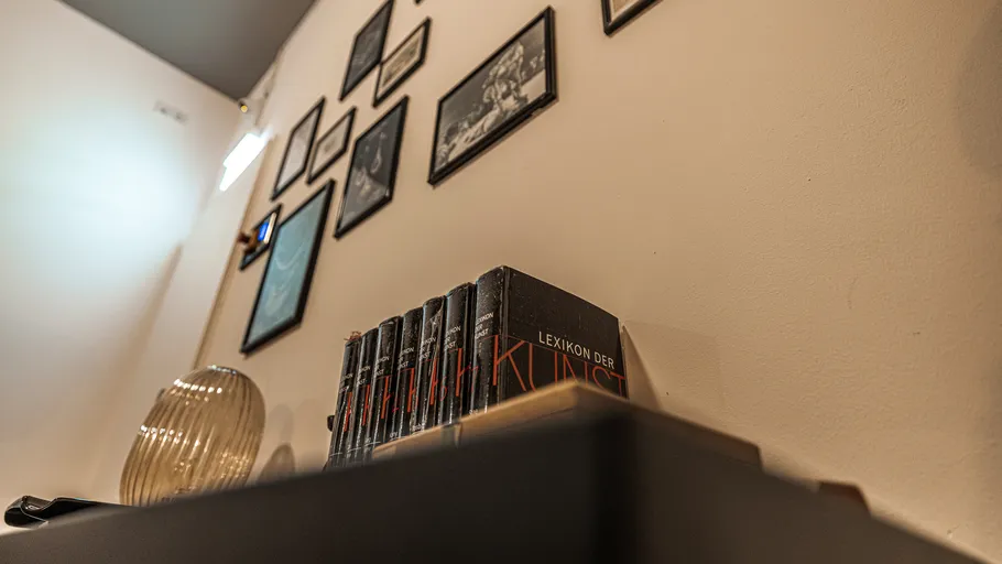 Bücher und Fotos auf einer geneigten Regalwand.