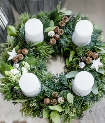 Adventskranz mit Kerzen und Dekorationen.
