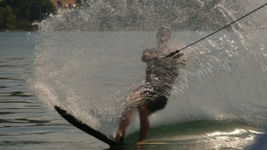 Person waterskiing, creating a large splash.