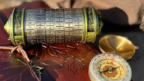 Cryptex und Kompass auf dekorierter Oberfläche.