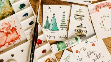 Farbpalette mit Weihnachtskarten auf Tisch.