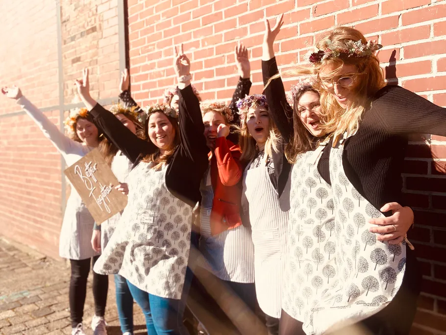 Different women party and pose in front of a brick wall.
