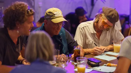 Group of people writing at a table.