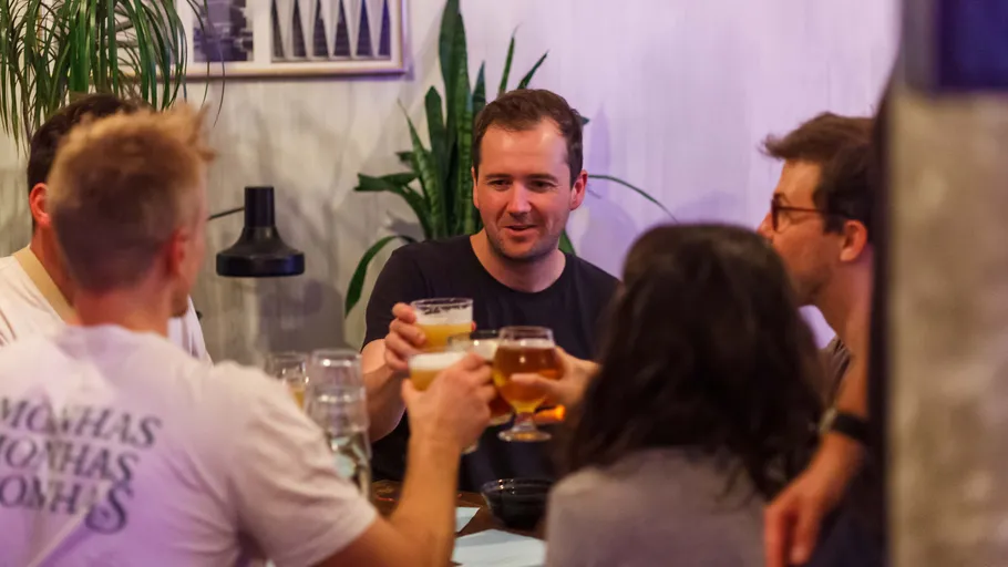 Group of friends toasting with drinks indoors.
