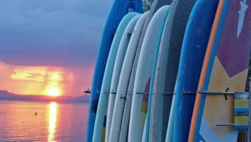 Paddleboards bei Sonnenuntergang am See gestapelt.