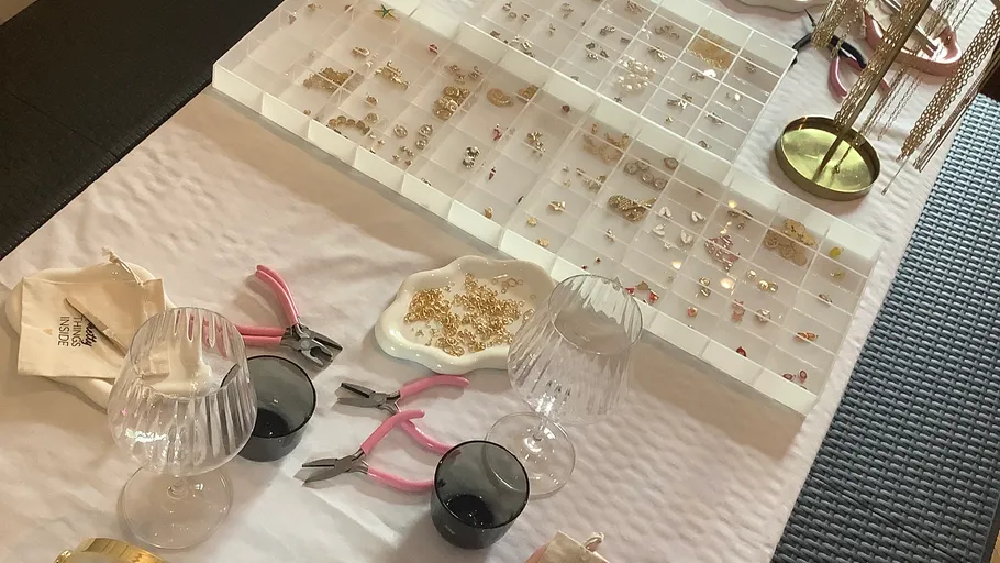 Jewelry-making tools and pieces on table.