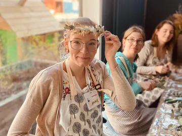 Woman with flower wreath in a creative workshop.