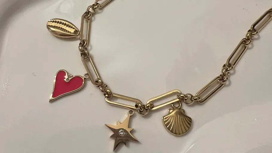 Gold chain necklace with assorted charms.