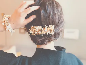 Hair with hair accessories and arm in a room.