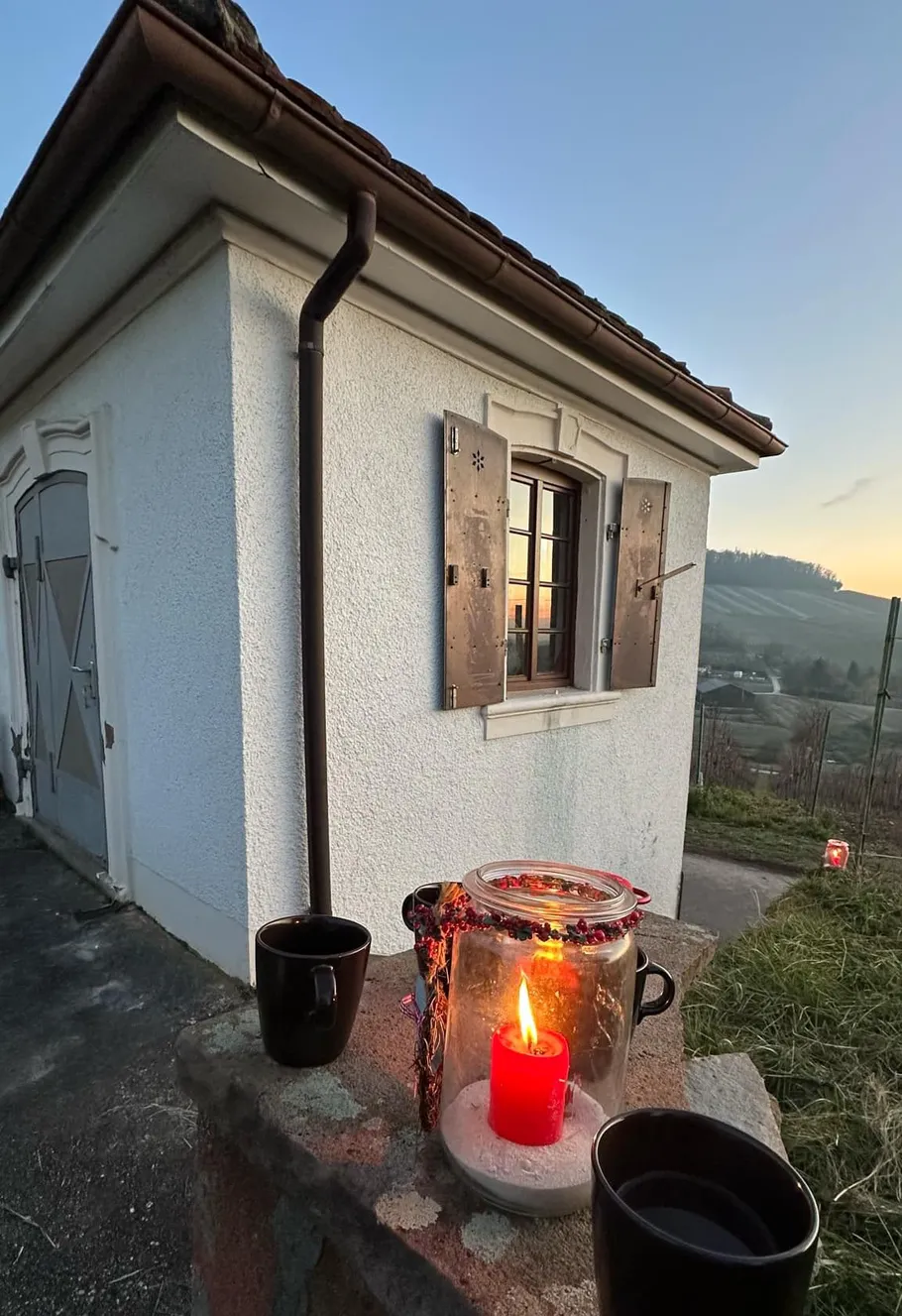 Kerze auf Mauer, kleines Gebäude, Sonnenuntergangssicht.
