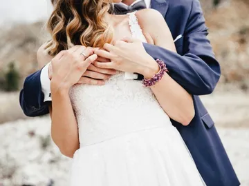 Hochzeitskleid, umarmende Paare, natürliche Umgebung, romantische Atmosphäre.
