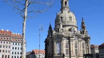 Baroque church with dome in sunny city square.