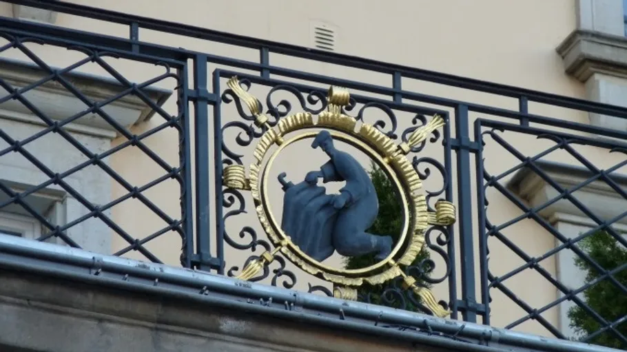 Ornate balcony railing with golden emblem.