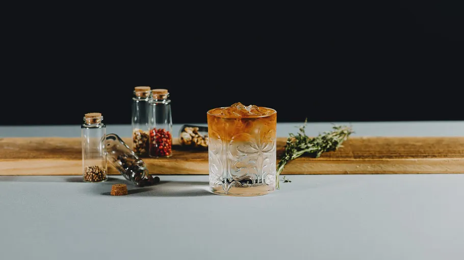 Glas Cocktail mit Gewürzen und Kräutern.