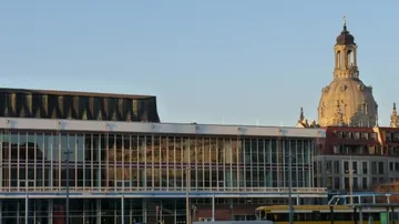 Modern building with church dome nearby.