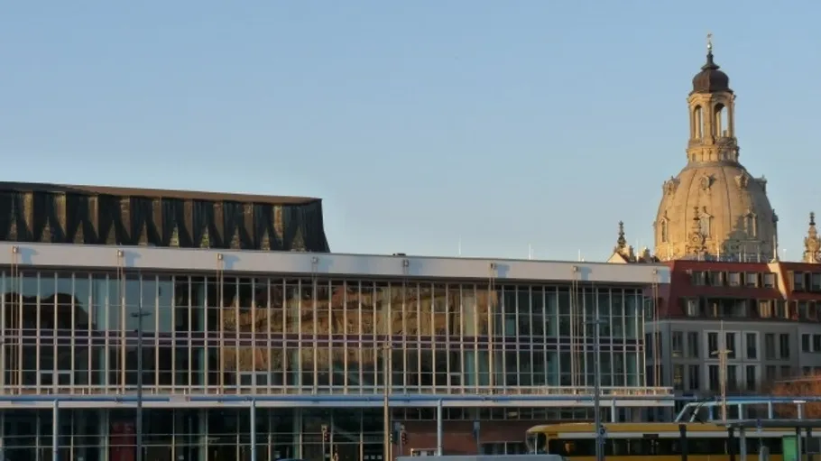 Modern building with church dome nearby.