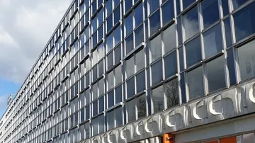 Glass building facade, sky reflection, daytime.