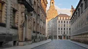 Cobblestone street with historic buildings, dome view.