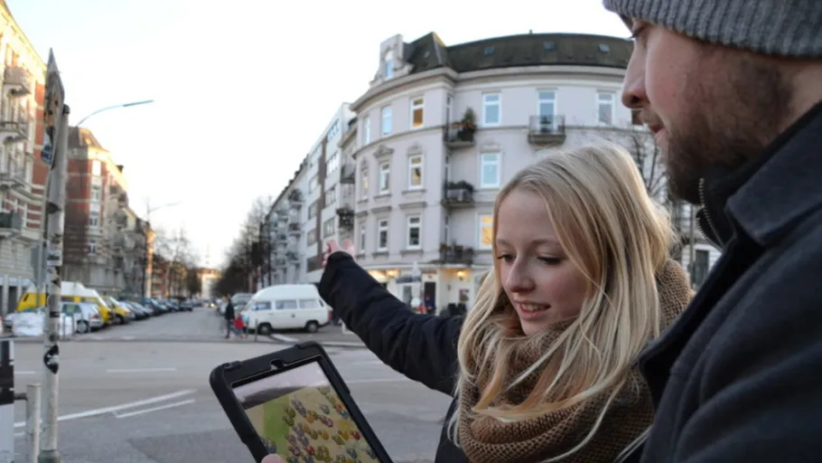 Zwei Personen betrachten Tablet, Straßenansicht.