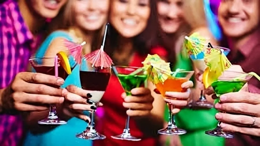 Personen halten bunte Cocktails bei einer Party.