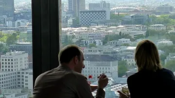 Two people dining with a city view.