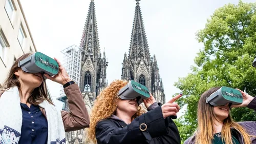 Personen mit VR-Headsets nahe dem Kölner Dom.
