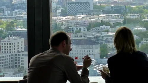 Zwei Personen essen mit Stadtblick.