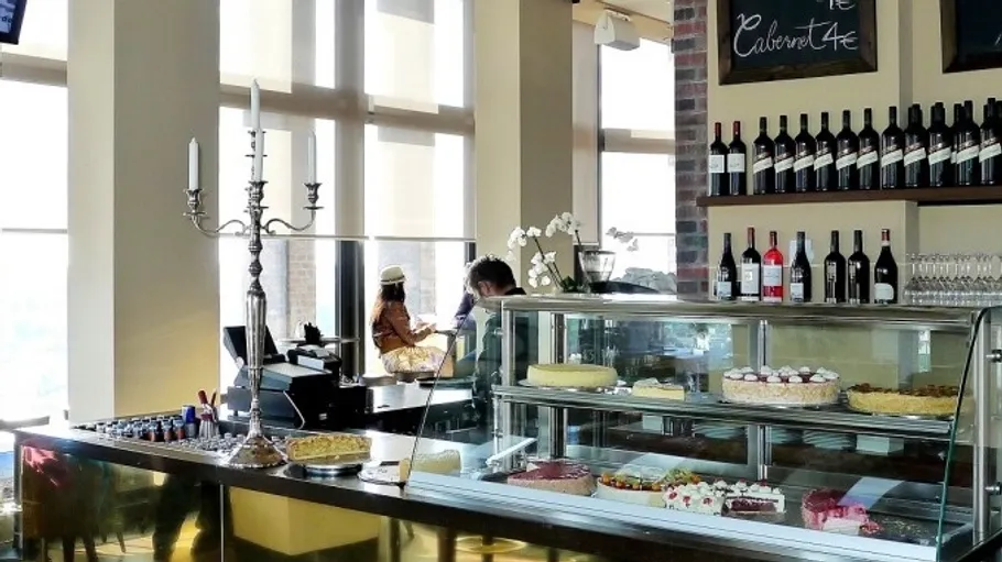 Café mit Gebäck und Weinflaschen ausgestellt.