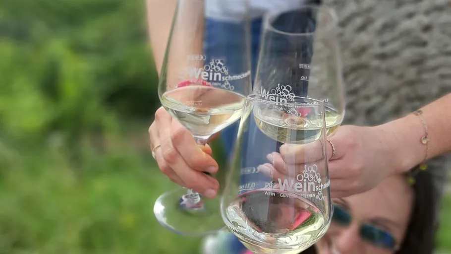 Hands holding wine glasses outdoors.