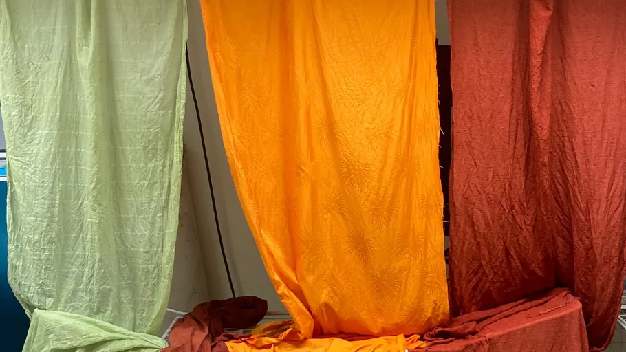 Three colorful fabric drapes hanging indoors.