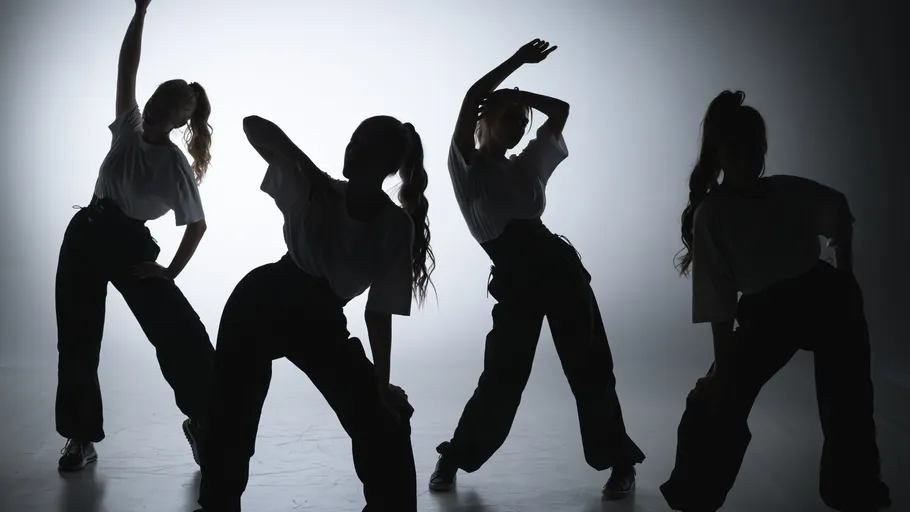 Vier Personen in Silhouette beim Tanzen.