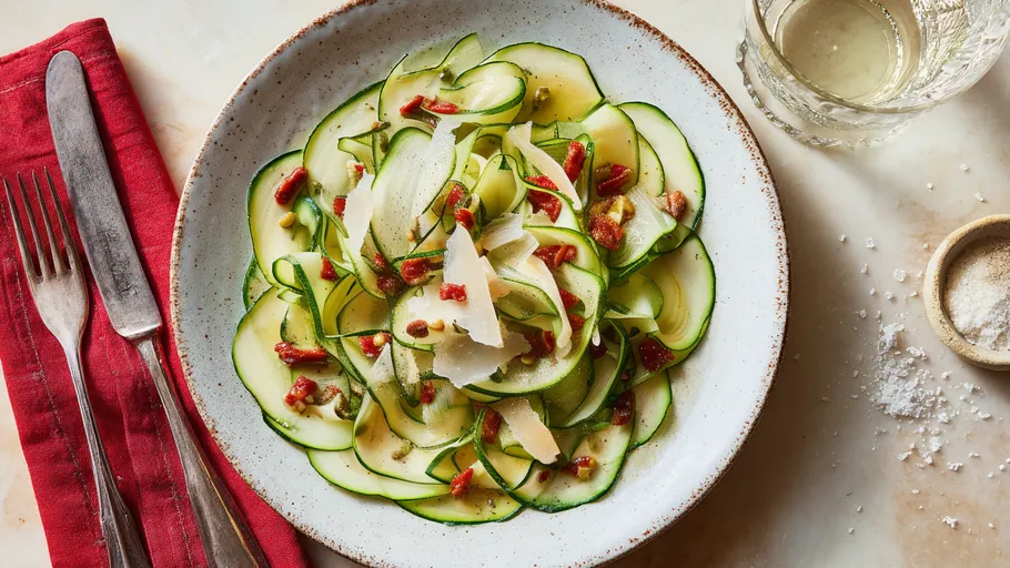 Zucchini-Salat mit Käse und Nüssen auf Teller.