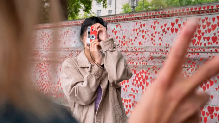 Person fotografiert vor herzgemusterter Wand.