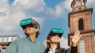 Zwei Personen genießen VR nahe historischem Gebäude.